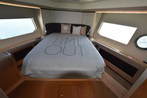 Absolute 50 Fly: full-beam master cabin with large double bed, wide hull windows and timber trim