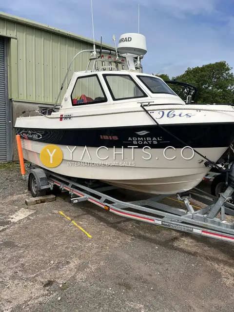 Admiral Shipyard Pro Fish 560: starboard bow view on trailer beside a green shed, radar dome on the wheelhouse roof