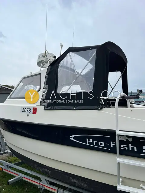 Admiral Shipyard Pro Fish 560: port side showing black canvas wheelhouse extension with clear windows and Pro-Fish hull graphics
