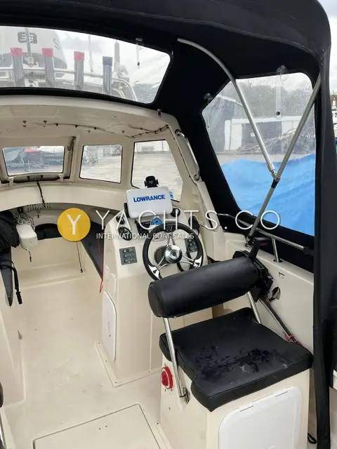 Admiral Shipyard Pro Fish 560: helm under the canvas extension, Lowrance display, wheel and bolster seat, cuddy beyond
