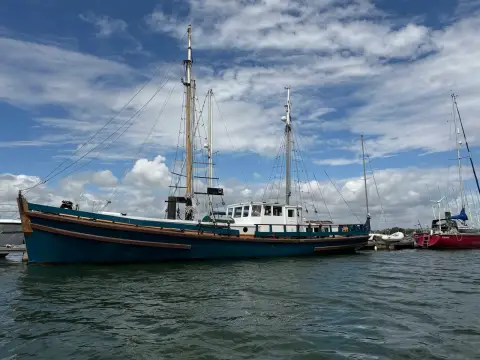 Admiralty Ketch: bow quarter view from the water showing white wheelhouse and tall wooden masts