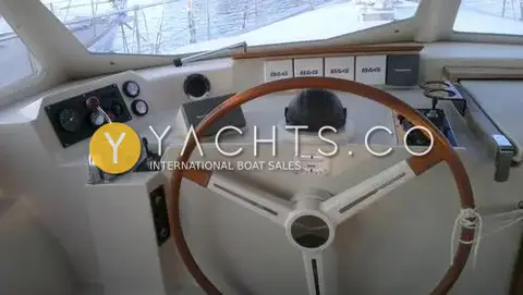 Amel Super Maramu 2000: helm station with wooden wheel, engine gauges and B&G instruments under the windscreen