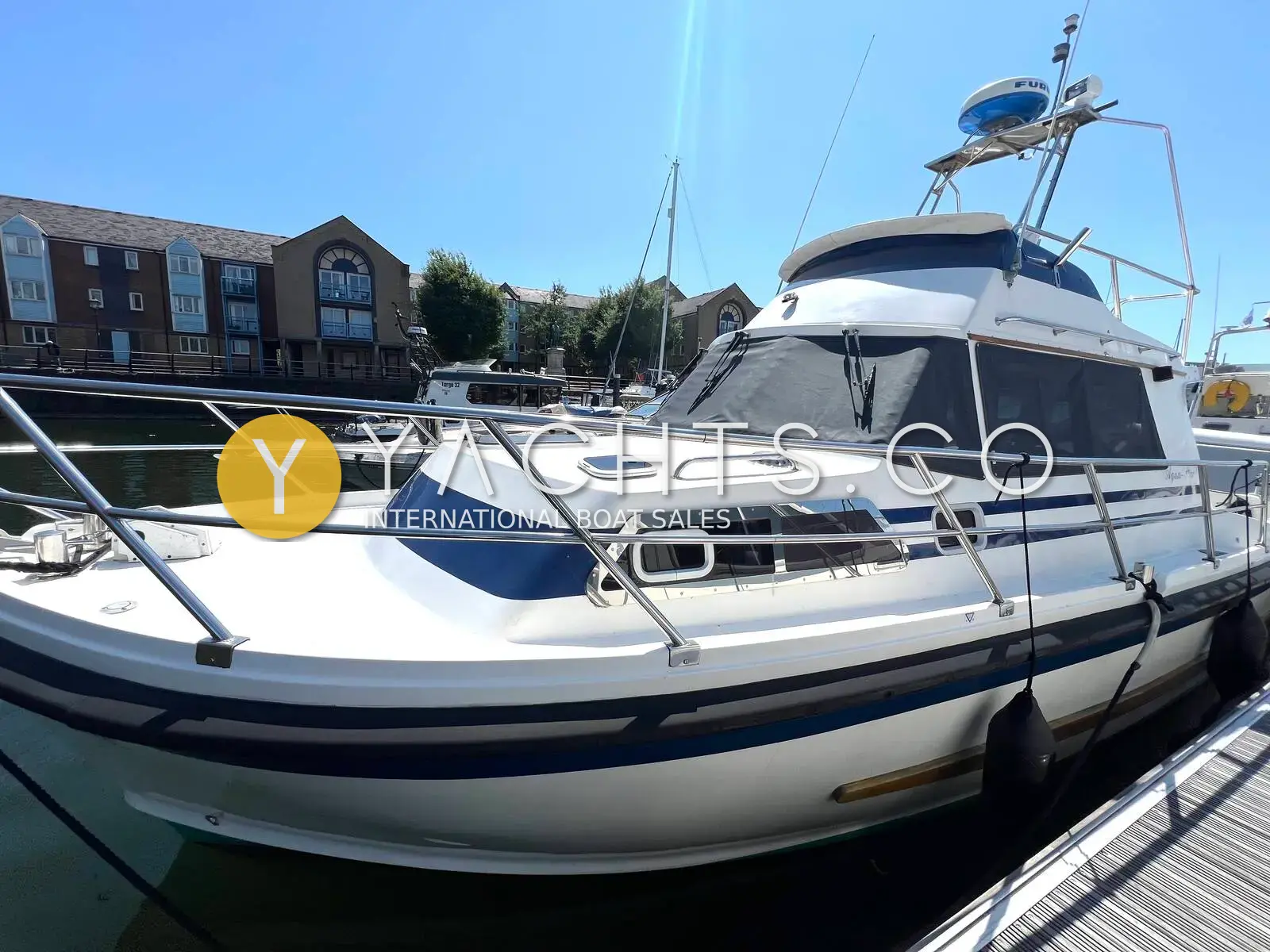 Aquastar Oceanranger 33: port bow view of white hull with navy stripes and radar arch, moored in marina