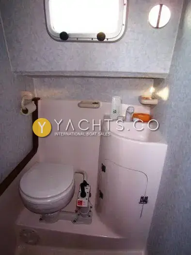Aquastar Pacesetter 27 Boat For Sale: heads compartment with sea toilet, moulded hand basin and opening portlight above