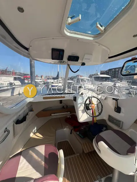 Arvor 210: wheelhouse interior with helm, striped seats, teak-effect sole and roof hatch