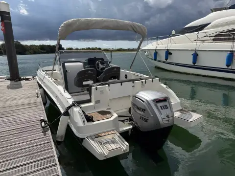 Atlantic Sun Cruiser 630: aft view of cockpit, twin swim platforms and Mariner outboard beside a wooden pontoon