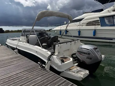 Atlantic Sun Cruiser 630: stern quarter from the pontoon showing outboard, swim platforms and cockpit under bimini