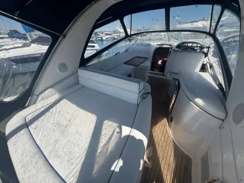 Bavaria 27 Sport: cockpit under camper cover with cream sunpad, seating and teak laid floor