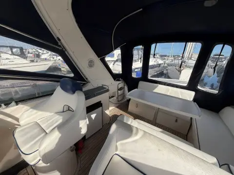 Bavaria 29 Sport: cockpit seating and wet bar seen from the helm under dark canvas