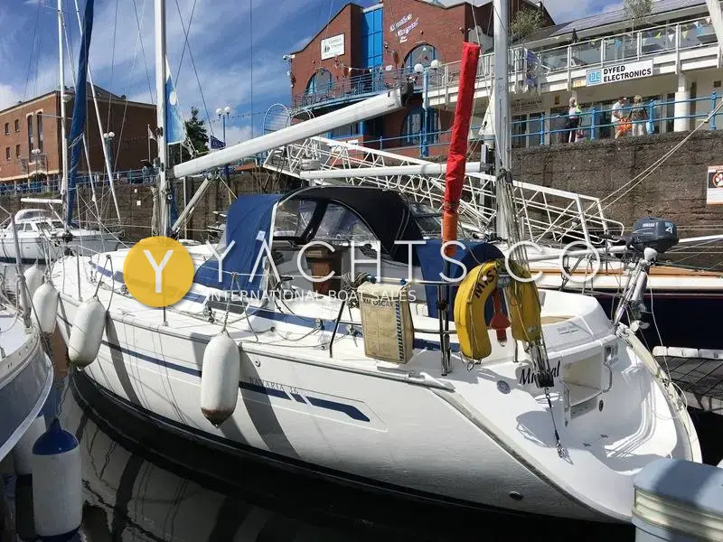 Bavaria 36: starboard quarter afloat in marina beside quay buildings, sprayhood and lifebuoy on pushpit