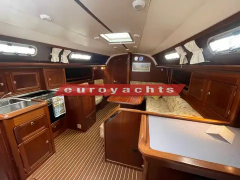 Bavaria 37: saloon looking forward with galley to port, offset table and starboard settee