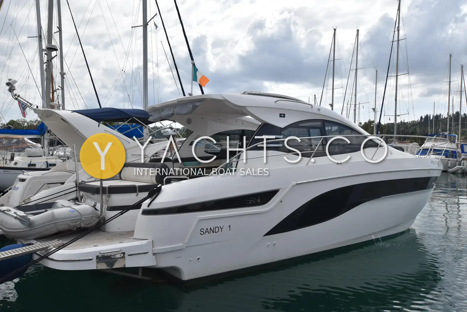 Bavaria SR41: starboard side view in a Corfu marina showing hardtop, black hull windows and tender on platform