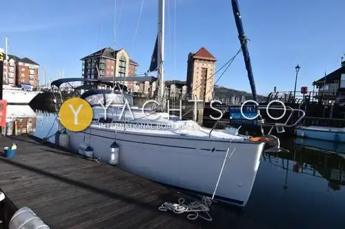 Bavaria Yachts Bavaria 30 Cruiser: starboard bow view of the white hull moored on a pontoon in a marina with brick buildings