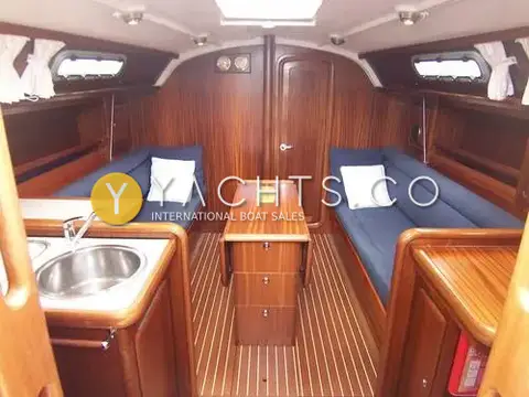 Bavaria Yachts Bavaria 34: saloon with blue upholstered settees, drop-leaf table and galley sink in the foreground
