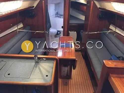 Bavaria Yachts Bavaria 36: saloon looking forward, hardwood joinery, blue settees, folding table and heads door open