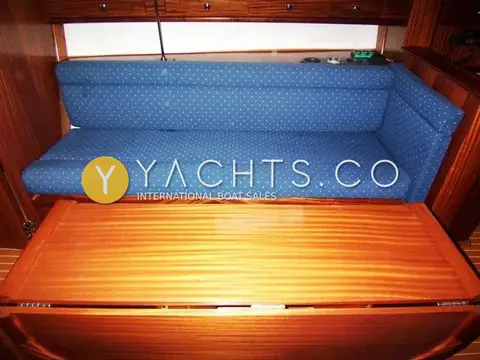 Bavaria Yachts Bavaria 36 Cruiser: saloon settee in blue patterned fabric behind the folded wooden drop-leaf table