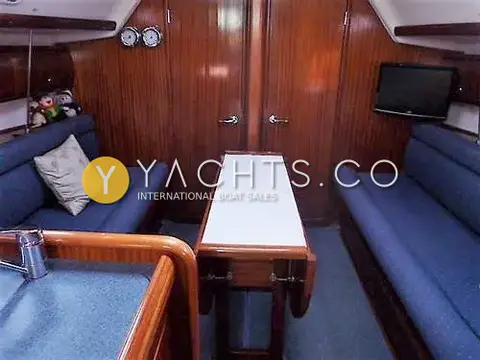 Bavaria Yachts Bavaria 36 Cruiser: saloon with blue upholstered settees either side of a drop-leaf table and wall TV