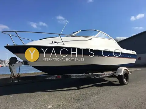 Bayliner 192 Cuddy: starboard bow with stainless bow rail and name on hull, harbour behind