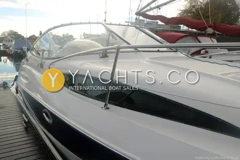 Bayliner 245: port side close-up of the curved hull window, guardrail stanchion and wraparound windscreen