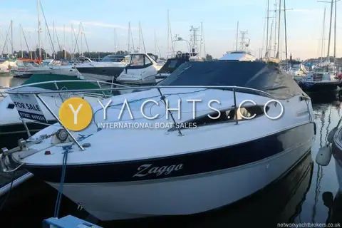 Bayliner 245: bow and port side with navy hull band, name on the topsides and cockpit cover on