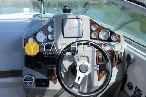 Bayliner 255: helm dashboard with wood-effect panels, analogue gauges, Garmin display and steering wheel