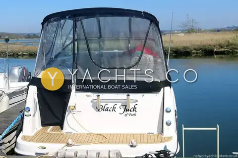 Bayliner 255: stern view showing canopy, transom rod holders and teak-effect swim platform on the river