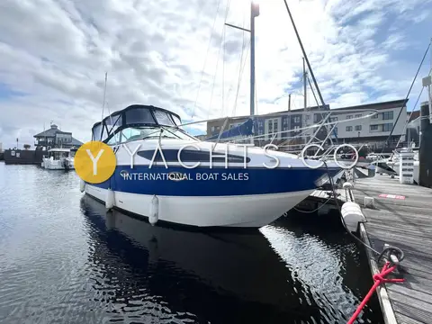Bayliner 265: starboard bow view of the hull and full cockpit enclosure on a calm marina berth