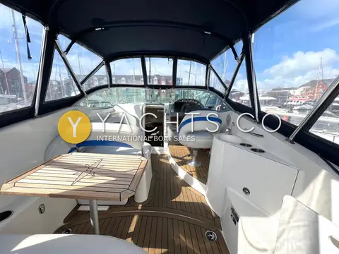 Bayliner 265: cockpit under the enclosure with teak table, flexi teak flooring and white seating