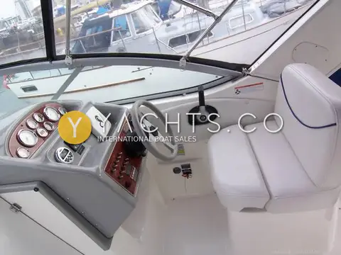 Bayliner 285: helm station with wood-effect dash, gauges, throttle and white bucket seat