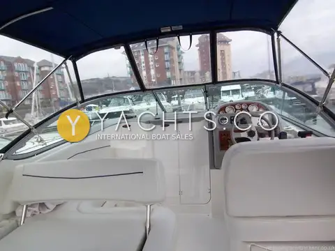 Bayliner 285: cockpit under blue canopy looking forward to helm and windscreen