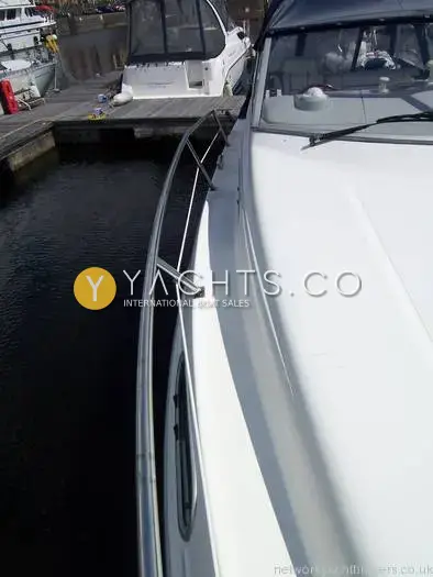 Bayliner Trophy 2152: side deck with stainless guardrail running forward alongside the wheelhouse, moored in a marina