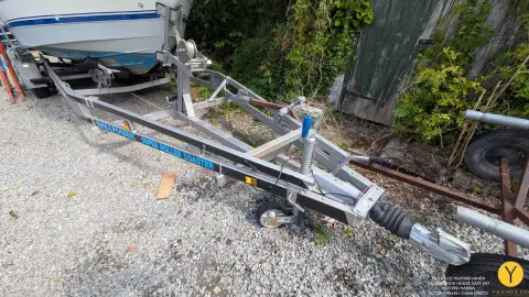 Bayliner Trophy Walkaround 2102: galvanised twin axle road trailer drawbar and winch post, empty, on gravel