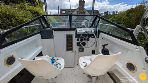 Bayliner Trophy Walkaround 2102: helm area with two white pedestal seats, wheel and wraparound windscreen