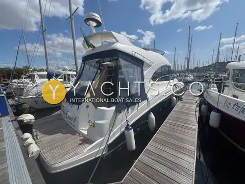 Beneteau Antares 30: stern view showing teak swim platform, blue cockpit enclosure and flybridge above