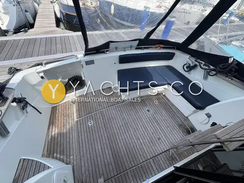 Beneteau Antares 30: teak-laid cockpit with navy U-shaped seating under clear enclosure panels
