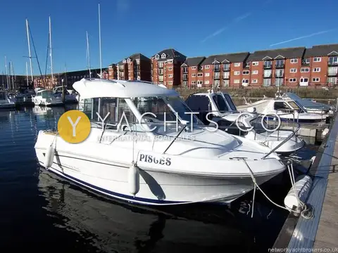 Beneteau Antares 5.80: pisces alongside a marina pontoon in sunshine, showing her wheelhouse, guardrails and blue boot stripe