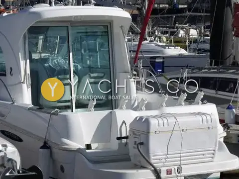 Beneteau Antares 6: aft wheelhouse doors, cockpit rod holders and large white cool box in cockpit