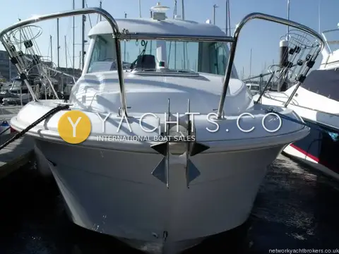 Beneteau Antares 6: head-on bow view with stainless anchor, pulpit rails and fender baskets at pontoon