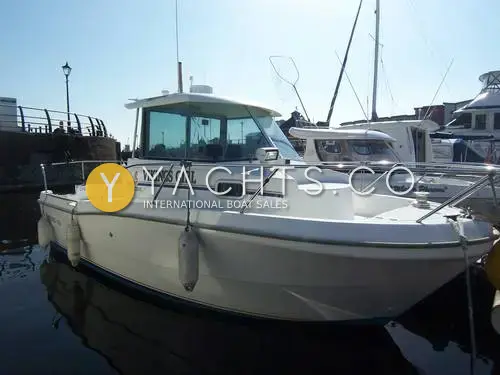 Beneteau Antares 620: starboard bow view of the white hull and wheelhouse moored in a sunny marina basin