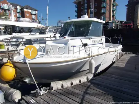 Beneteau Antares 620: port side view alongside a pontoon with fenders out, apartments behind