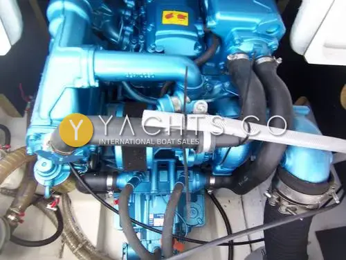 Beneteau Antares 7: engine bay viewed from above, showing the blue-painted diesel inboard with hoses and clamps