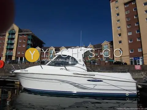 Beneteau Antares 7: port side profile of the white hull with navy stripe and Antares logo