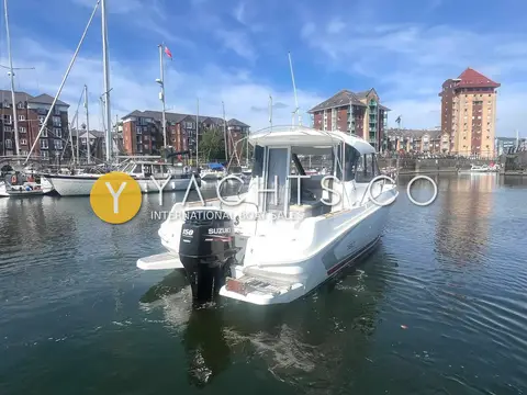Beneteau Antares 7.80: stern view showing single black outboard and walkaround deck in a marina basin