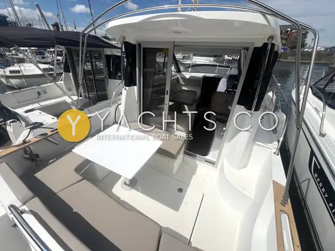 Beneteau Antares 7.80: cockpit with table, bench seating and open doors leading into the wheelhouse