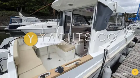 Beneteau Antares 7.80: cockpit with beige cushioned seating, white table and open sliding doors to wheelhouse