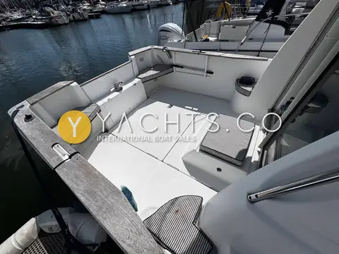 Beneteau Antares 710: cockpit with cream cushioned seating around the transom and wooden coamings