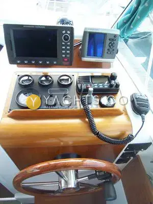 Beneteau Antares 760: helm console with chartplotter, fishfinder, VHF radio, engine gauges and wooden wheel