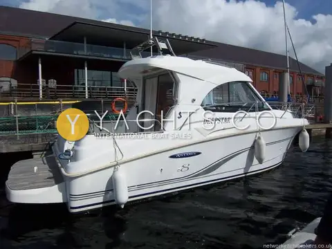 Beneteau Antares 8: starboard quarter view showing cockpit, wheelhouse door and radar arch, moored by a modern building
