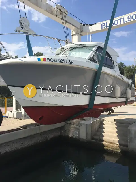 Beneteau Antares 8 Classic: hull lifted in travel hoist slings, showing red antifouled bottom and registration number