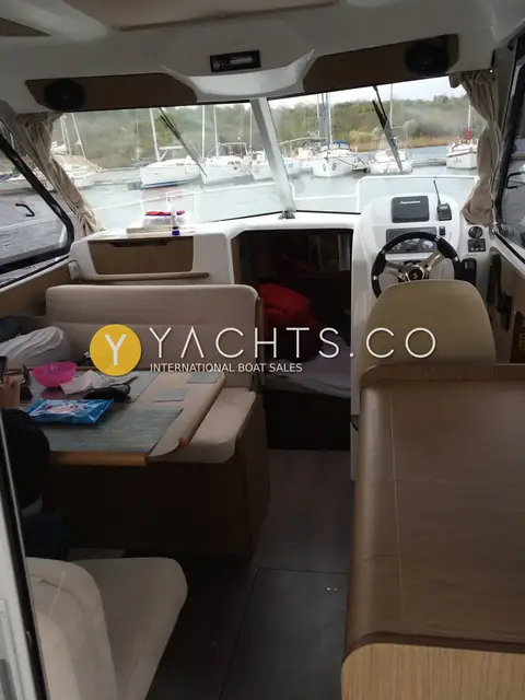 Beneteau Antares 8 Classic: wheelhouse saloon looking forward to helm, dinette with table and bench seating